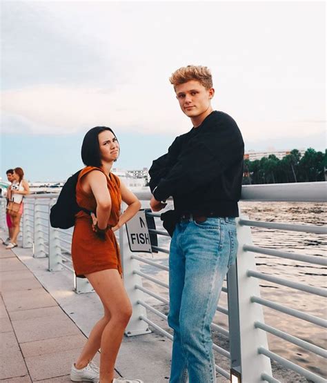 two people standing next to each other on a pier