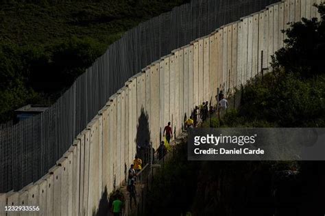 Demonstrators walk behind the Lebanon-Israel border wall during a ...