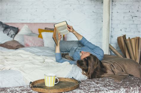 Young woman reading book on bed stock photo containing woman and reading | People Images ...