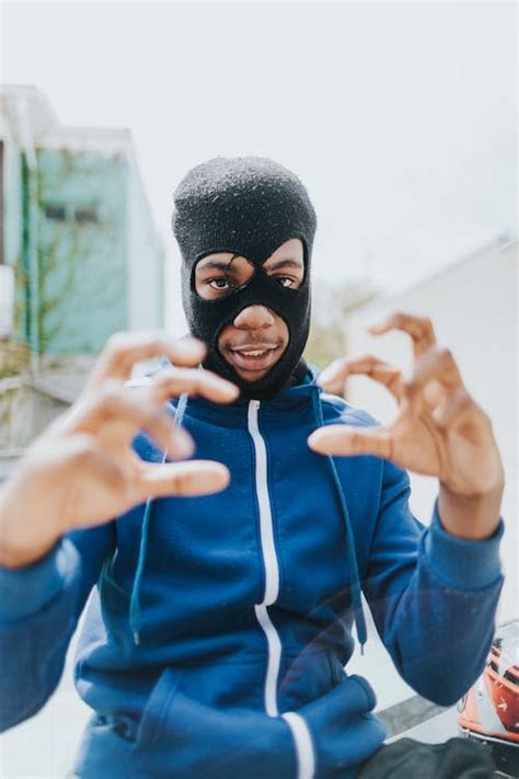Man in Blue and Black Nike Zip Up Hoodie Covering His Face With His Hand · Free Stock Photo