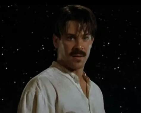 a man with a moustache standing in front of stars