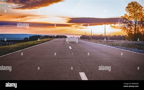 Country road at sunset Stock Photo - Alamy