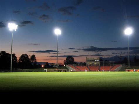 an empty soccer field is lit up at night