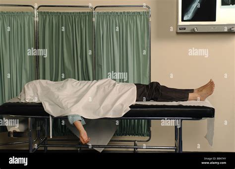 a dead body lying in a NHS hospital morgue during a COVID 19 Epidemic - posed by a model Stock ...