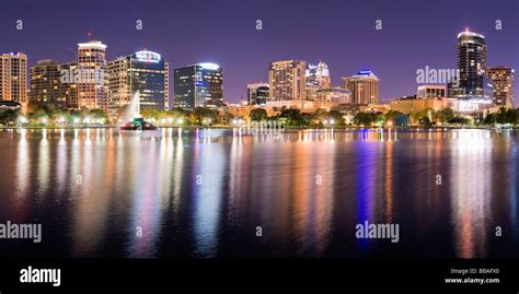 Glowing nighttime downtown skyline of Orlando Florida reflects in Lake ...