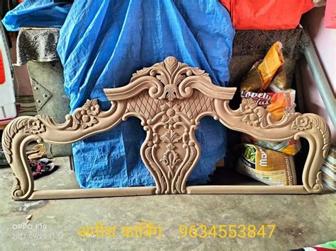 an ornately carved wooden bed frame sitting on top of a floor next to ...