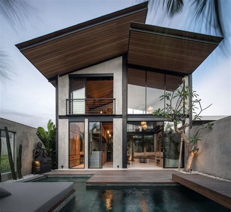 a house with a pool in front of it and a deck leading to the outside