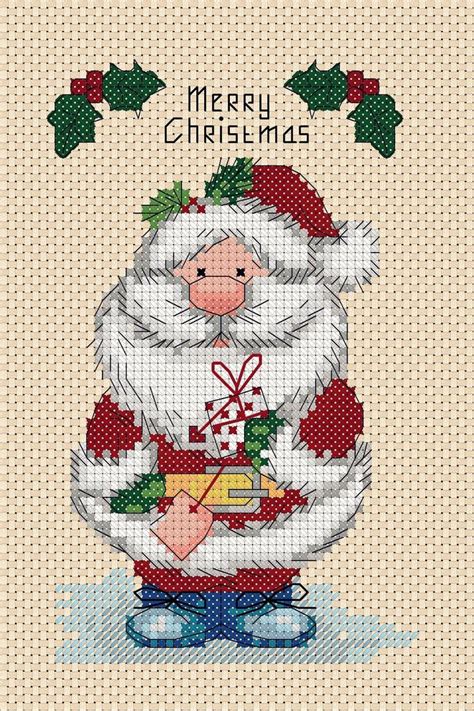 a cross stitch christmas card with a santa clause holding a bag and ...