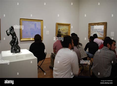 Group of adults at art museum. People sitting watching at famous art ...