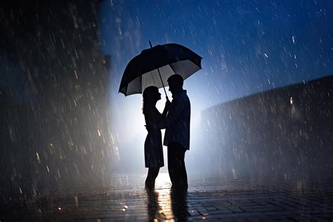 Silhouette a couple standing under an umbrella in the rain. 23978659 ...