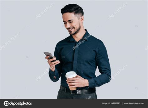 Man holding mobile phone and coffee mug Stock Photo by ©gstockstudio 142998775