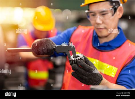 engineer worker using Vernier Caliper to check gear size for accuracy ...