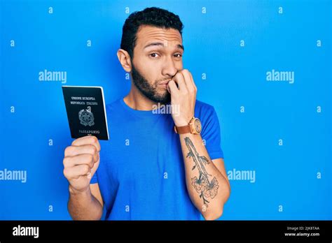 Hispanic man with beard holding italy passport looking stressed and ...