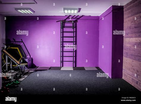 Empty gym fitness hall with sports equipment and a ladder on the wall Stock Photo - Alamy