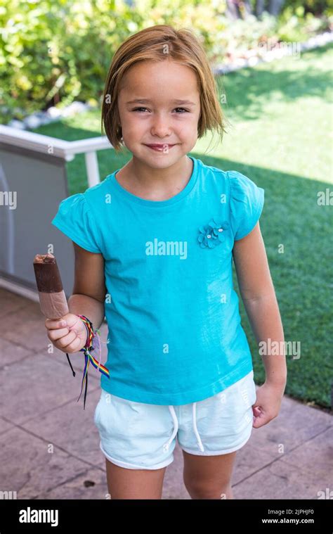 Unknown girl, wearing a green t-shirt, holding a milk chocolate ice ...