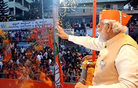 Prime Minister Narendra Modi waves at crowd during a roadshow