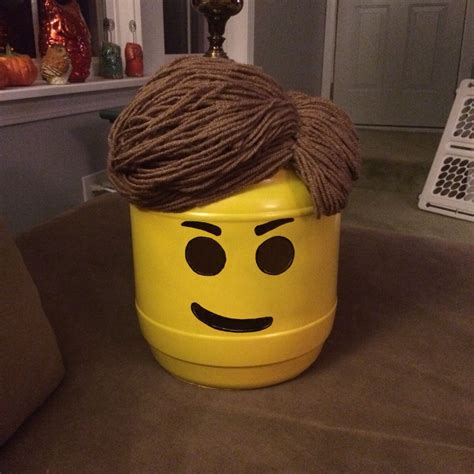 Lego Emmet costume piece I made out of a cheese ball container, brown yarn, and black mesh to ...