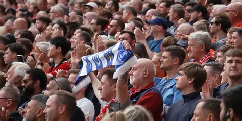 Liverpool fan holds Everton scarf aloft during minute's applause at Anfield