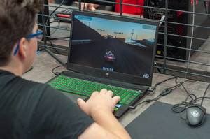 Ein Opa guckt sich das Wirtschaftssimulationsspiel und PC-Game Tropico auf einem Gaming-Laptop ...