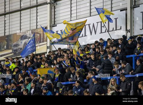 Warrington Wolves fans waving fans as the teams warm up Stock Photo - Alamy