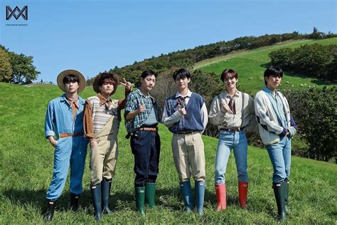five young men are standing in the grass wearing well - worn clothes ...
