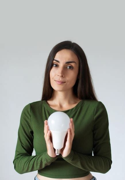 Premium Photo | Girl holding a led light bulb using economical and ...