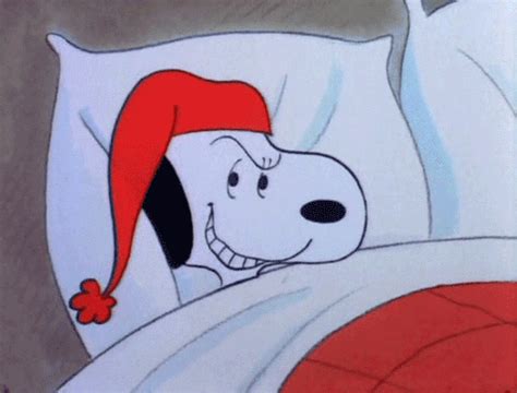 a cartoon dog laying in bed wearing a red hat