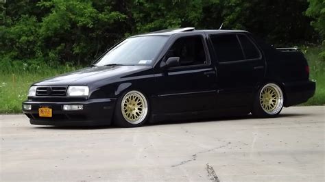 a black van with gold rims parked in a parking lot