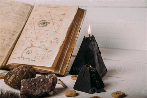 Open old book with magic spells, runes, black candle 7137370 Stock Photo at Vecteezy