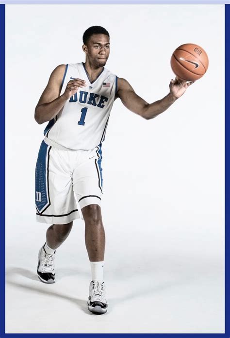 a man holding a basketball while standing in front of a white background with the words duke on it