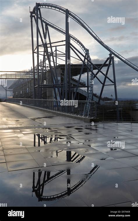 The roller coaster "Ring Racer" is reflected in a puddle at the Nuerburgring at sunset in ...