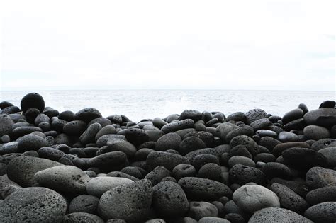 Pile of rocks beside beach under clear white sky HD wallpaper | Wallpaper Flare