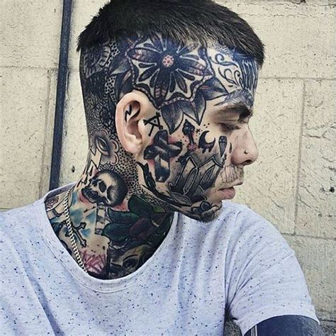 a man with tattoos on his face and neck