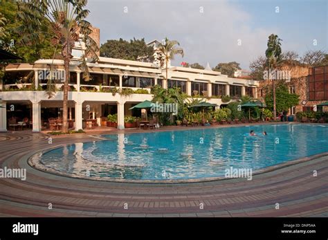 Nairobi Serena Hotel swimming pool with two swimmers Kenya Stock Photo - Alamy