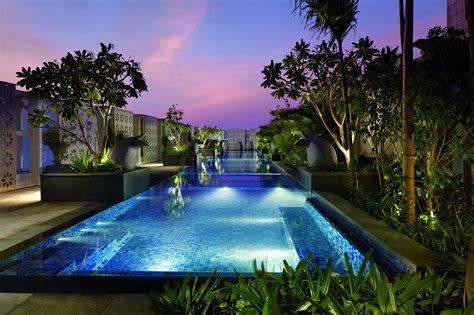 Evening view from the end of a rectangular swimming pool surrounded by plants Luxury Spa, Luxury ...