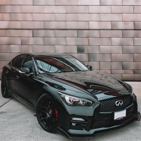 a black sports car parked in front of a brick wall