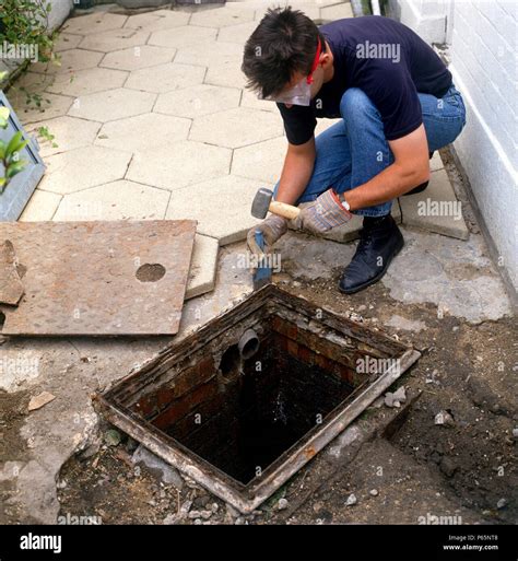 Installing a manhole cover over the drain Stock Photo - Alamy