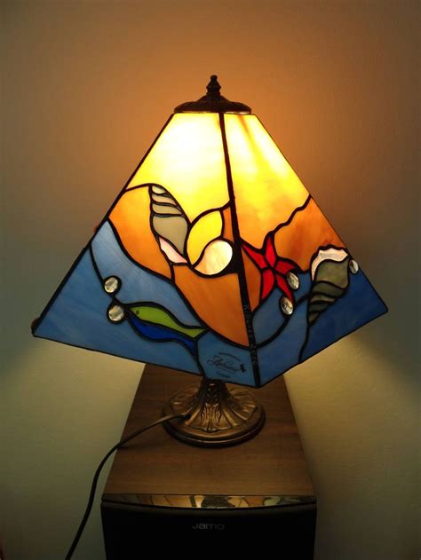 a stained glass lamp sitting on top of a wooden table