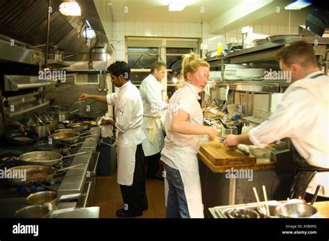 Team of restaurant kitchen staff busy at work Stock Photo - Alamy