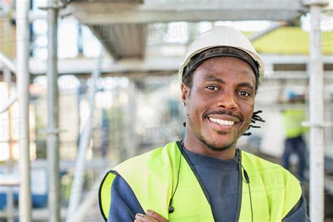 Portrait of happy construction worker at site - Stock Photo - Dissolve