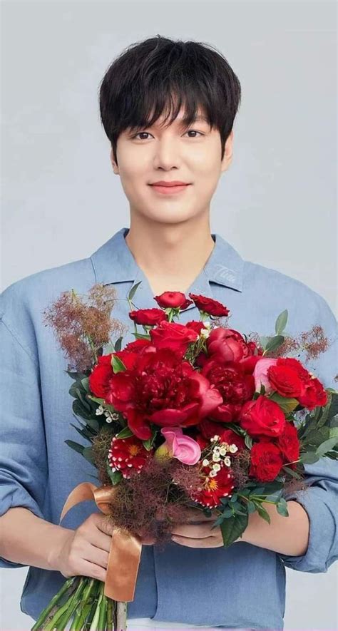 a man holding a bouquet of red flowers