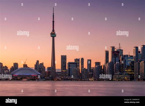 Toronto Skyline at sunset featuring the CN Tower across Lake Ontario ...