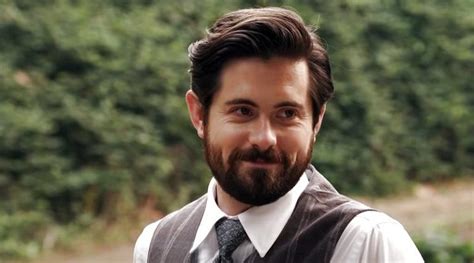 a man with a beard wearing a vest and tie