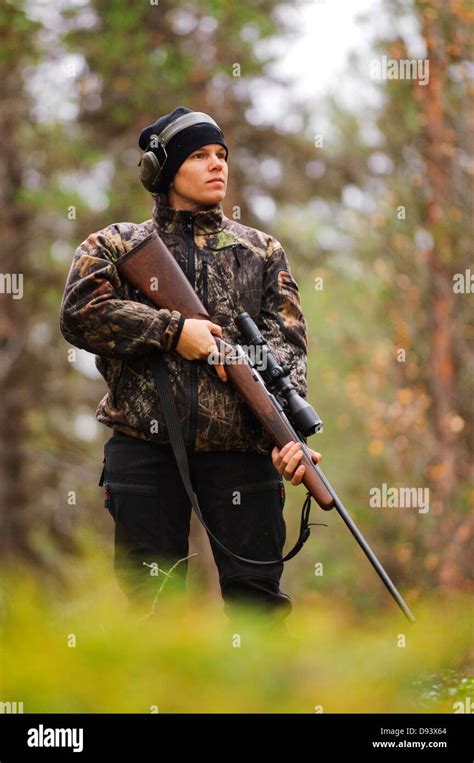 Hunter holding rifle in forest and looking away, low angle view Stock ...