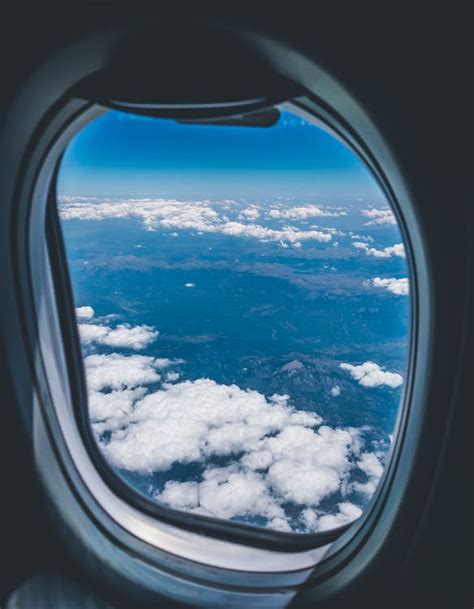 Airplane Window View of White Clouds over Mountain · Free Stock Photo