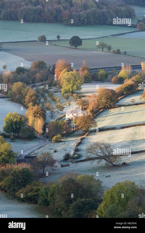 House and farmland in the valley of Downham Hill from Uley Bury on a cold frosty autumn morning ...