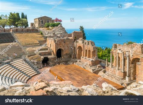 Ruins of the Ancient Greek Theater in Taormina on a sunny summer day with the mediterranean sea ...