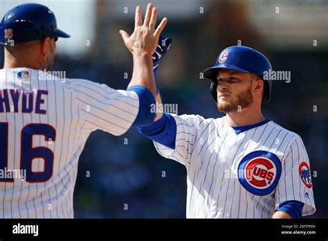 Chicago Cubs' Ian Happ, right, celebrates with first base coach Brandon Hyde after hitting a ...