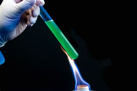 Set of laboratory glassware with chemical multi-colored solutions on a black background ...