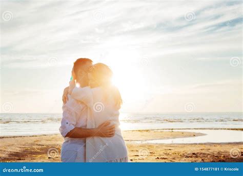 Love, Sunset, Romance. a Young Couple in Long White Soft Clothes Hugging Against the Backdrop of ...